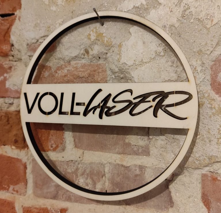 Holzschild mit der Aufschrift "VOLL-LASER" in einer runden Form.